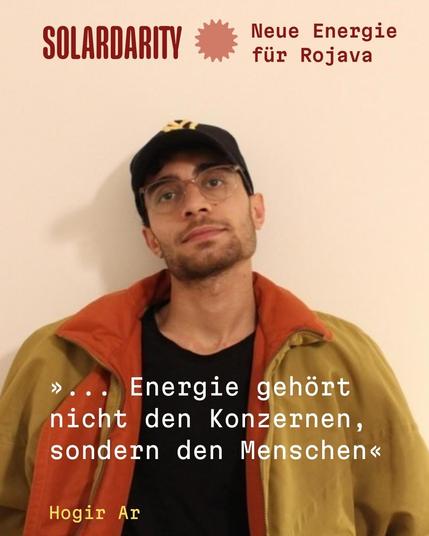 Ein junger Mann mit Brille, dunklem Bart, schwarzem Basecap und bunter Jacke blickt leicht nach oben. Oben links steht in roter Schrift:
"SOLARDARITY Neue Energie für Rojava"
Unten im Bild steht in weißer Schreibmaschinenschrift:
"… Energie gehört nicht den Konzernen, sondern den Menschen"
Darunter in Gelb:
"Hogir Ar"