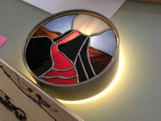 Same stainless still circle (piece of a tube 150mm diameter). Tiffany with volcano in it. Light comes behind it, highlighting the lava and also comes from behind the lamp.