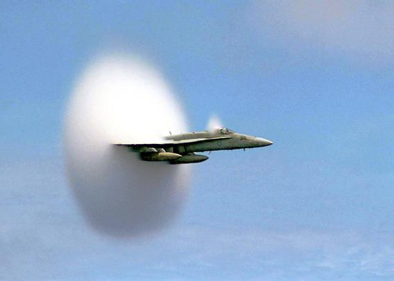2007 August 19

A Sonic Boom
 * Credit: Ensign John Gay, USS Constellation, US Navy

Explanation: 
Is this what a sonic boom looks like? When an airplane travels at a speed faster than sound, density waves of sound emitted by the plane cannot precede the plane, and so accumulate in a cone behind the plane. When this shock wave passes, a listener hears all at once the sound emitted over a longer period: a sonic boom. As a plane accelerates to just break the sound barrier, however, an unusual cloud might form. The origin of this cloud is still debated. A leading theory is that a drop in air pressure at the plane described by the Prandtl-Glauert Singularity occurs so that moist air condenses there to form water droplets. Above, an F/A-18 Hornet was photographed just as it broke the sound barrier. Large meteors and the space shuttle frequently produce audible sonic booms before they are slowed below sound speed by the Earth's atmosphere. 

Authors & editors: Robert Nemiroff (MTU) & Jerry Bonnell (USRA)
NASA Official: Phillip Newman Specific rights apply.
NASA Web Privacy Policy and Important Notices
A service of: ASD at NASA / GSFC
& Michigan Tech. U.
