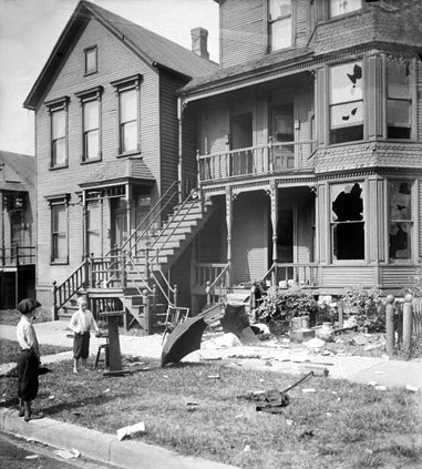 a house with broken windows and debris in the front yard during a race riot in Chicago, Illinois. Two young white boys are standing in front of the house and looking at it. a house with broken windows and debris in the front yard during a race riot in Chicago, Illinois. Two young white boys are standing in front of the house and looking at it.