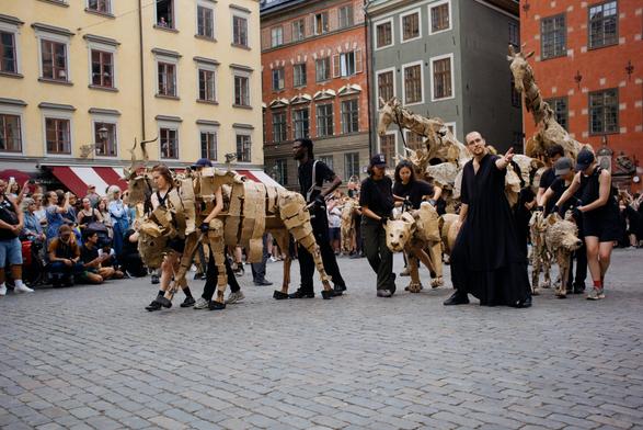 A group of artists with full size animal puppets in Gamla Stan.