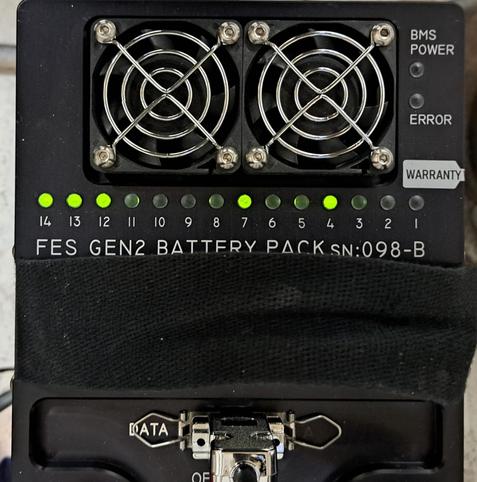 The top of the glider battery. Some of the LED's are lit, but not all. The battery management system is balancing all cells to have the same voltage.

Two small cooling fans are at the top of the photo. The data communication cable is at the bottom. The power connections for high-amperage work are not shown.