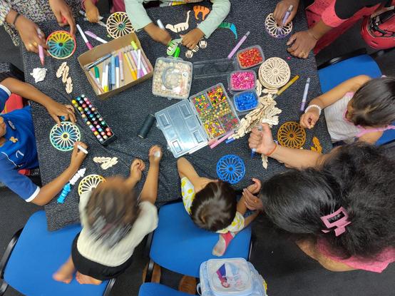 Kids sitting at a table making dreamcatchers.