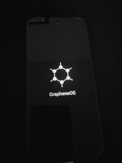 Ein Smartphone welches gerade startet und das Logo von GrapheneOS anzeigt.