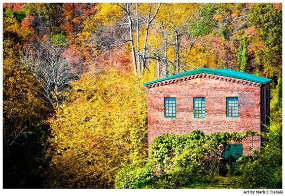 A color photo of an old red brick mill building surrounded by colorful fall foliage. Photo of the last remaining building from the old mill complex in Roswell, Georgia above Vickery Creek.