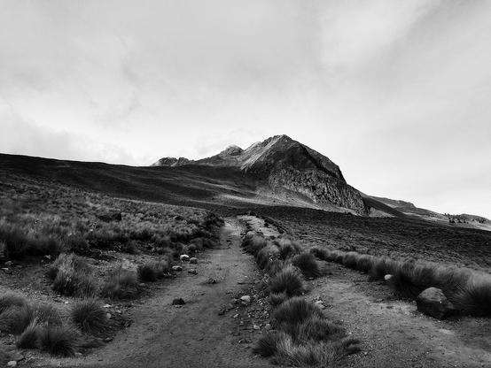 a B&W photo of trails towards a mountain near a volcanic area knowing as "nevado de toluca"