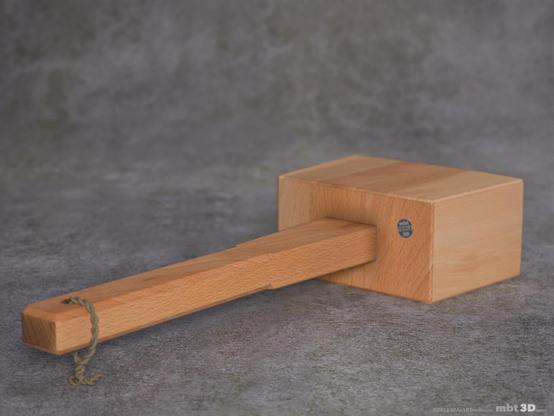 Beech wood mallet laying flat on a stone surface, viewed from the handle.