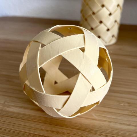 beige 3D printed takraw like rattan ball lying at the desk in front of 3D printed basket