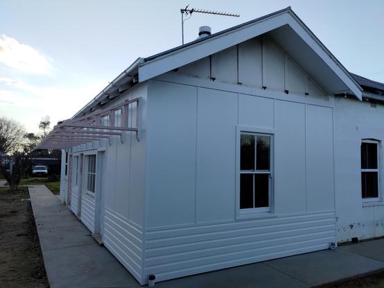 The freshly painted back rooms of my old house almost completely rebuilt in Federation style with panelled exterior walls above weatherboard. It looks just like it always did, but now it looks loved & cared for again.