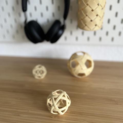 photo of 3d printed ribbon balls laying on the desk in different sizes and different ribbons