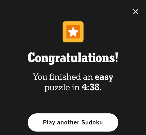 A congratulations screen from a puzzle app, with white text on a dark grey background, reads "Congratulations! You finished an easy puzzle in 4:38." A button at the bottom says "Play another Sudoku" in dark grey text on a white background, and a small yellow square with a white star is in the top center of the screen. A small white 'X' is visible in the upper right corner.