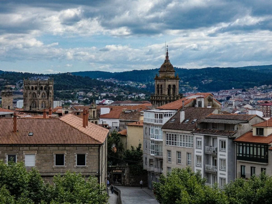 Image of buildings in town in Galicia with a mountain range in the back