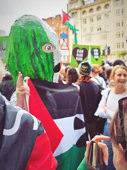 A man wearing a giant DJ Provai papier maché head