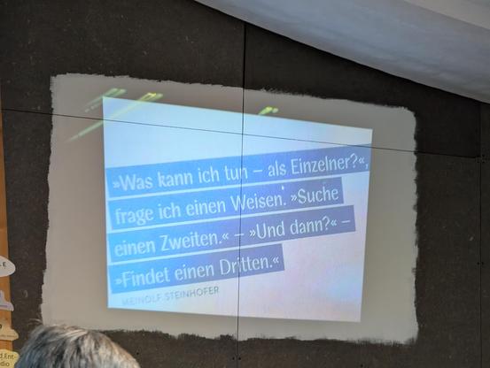 Ausschnitt einer Präsentation per Beamer mit dem Text:
"Was kann ich tun - als Einzelner?", frage ich einen Weisen.
"Suche einen Zweiten."
"Und dann?"
"Findet einen Dritten."