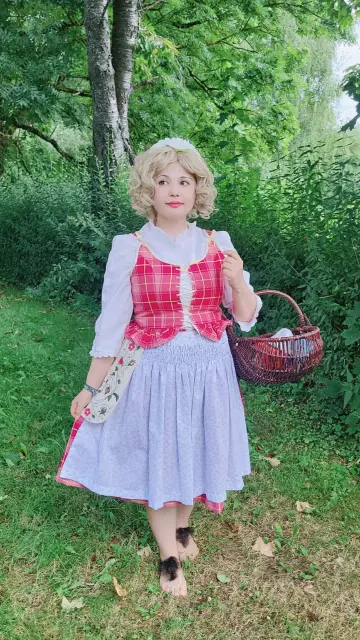 woman dressed as a hobbit in a red outfit with an apron and hairy feet