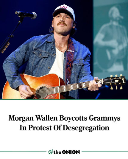 The image features a man on stage playing an acoustic guitar. He is wearing a denim jacket over a white shirt and a white cap with a red "W" on it. The man has a mustache and is looking upwards, possibly singing into a microphone. The background is dark with a blue hue, and there is a blurred image of another person playing a guitar on a screen behind him. The text at the bottom of the image reads, "Morgan Wallen Boycotts Grammys In Protest Of Desegregation," and the logo of "The Onion" is visible at the bottom right corner.