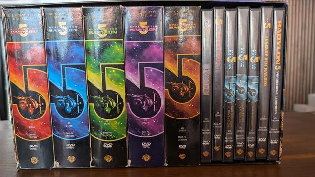 Komplettbox "Babylon 5 - The Complete Collection", alle Staffeln und Filme in einer Box. Die Serienboxen haben auf dem Rücken verschiedenfarbig prominent je eine große "5" aufgedruckt, die bei der fünften Staffel im Vergleich deutlich nach oben verschoben ist.
