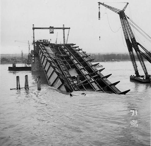 Ein Teil der eingestürzten Brücke liegt im Rhein. Daneben ein Kran.