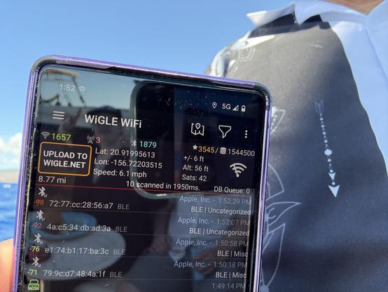 A close up of a phone running the WigleWiFi app on the ocean in Hawaii