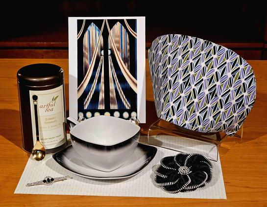 Dramatic tea tableau in white and black with Art Deco accessories and china, all from the era, and an Art Nouveau painting of a bridge. The tea is Summer Romance loose-leaf black and green tea flavored with papaya and sunflower, from Artful Tea Company.