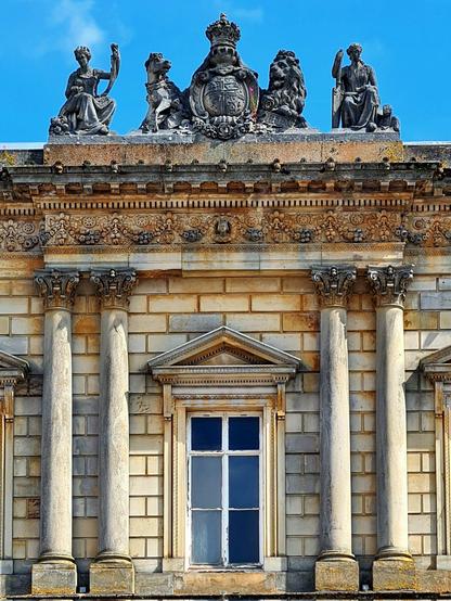 A Classical style building with sculpted figures along its roofline.