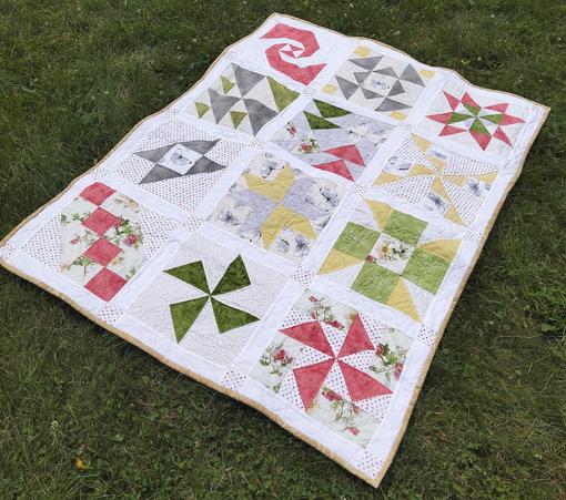 43 x 57 in (109 x 145 cm), it is light red and yellow and grey designs and some green on a light backing