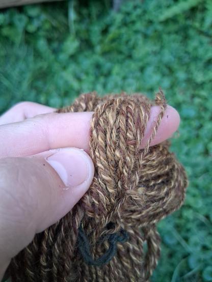 A close up of the yarn, showing off the color variation. The Angora has dyed a light yellow gold, the wool is a medium brass, and the Alpaca is the same cinnamon brown or dark copper tone as before.