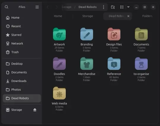 Shows a window on the Linux Desktop. The side panal lists places. The main window contains multicoloured rounded folders with various icons in the centre.