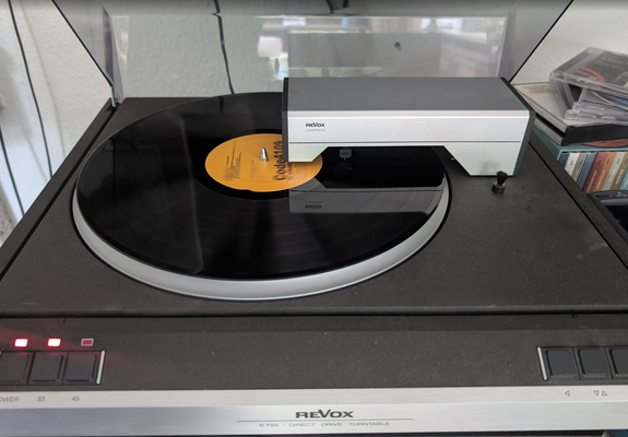 A Revox B795 turntable. It uses Revox's Lineartrack system which is an impressive tangential tonearm mechanism. The tonearm mechanism pivots onto the record and looks a bit like a bridge. The controls are very minimal, just power, 33, 45 (speed), forwards, backward and cueing.
