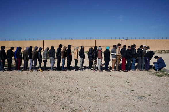 African male detainees at Qanfoodah Detention Center wait in line to be declared present at morning roll call on February 2, 2019, in Benghazi, Libya.