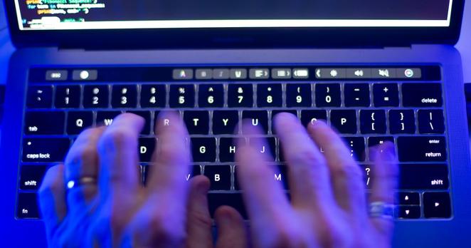 A person types on a computer keyboard in Toronto on Monday, Oct. 9, 2023, in this photo illustration. (THE CANADIAN PRESS/Graeme Roy)