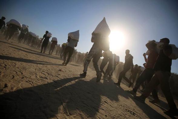 Palestinians, driven to the brink of starvation, gather at an aid distribution point in near Zikim, Northern Gaza, July 30, 2025. (Photo: Omar Ashtawy/APA Images)