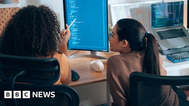Two workers looking at code
