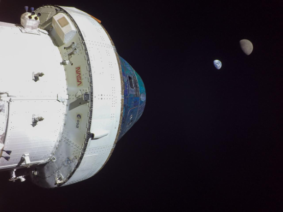Image of Artemis Orion Completing Final Lunar Departure Maneuver, December 2022 with a dark black background in space and a white spacecraft