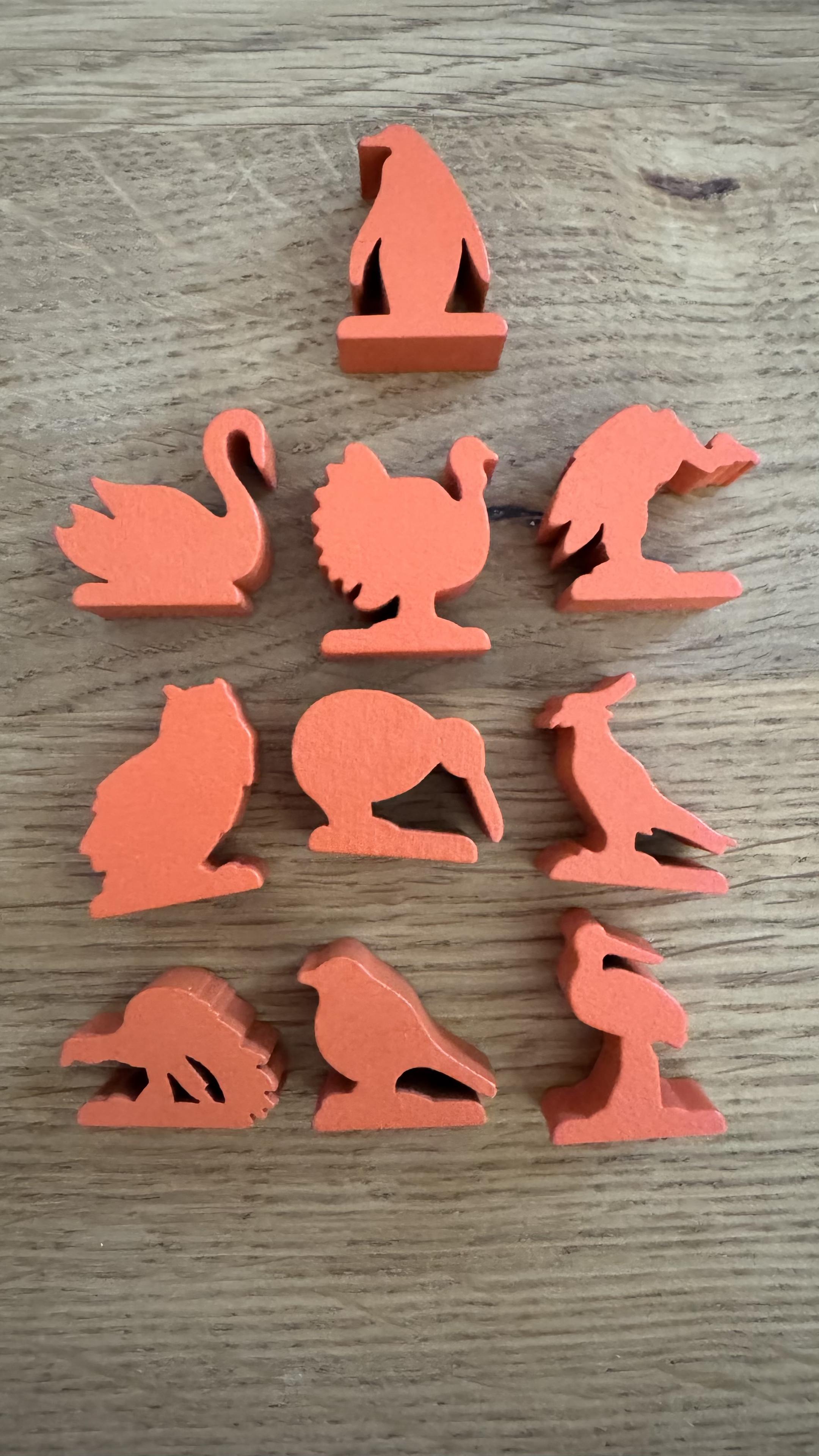 Verschiedene Vogelmeeple aus rotem Holz:
Pinguin, Schwan, Truthahn, Geier, Eule, Kiwi, Sekretär, ein Pfsu (?), ein Singvogel und ein Reiher.