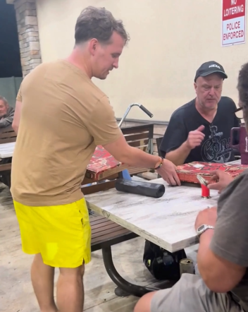 Jeremy McNally, co-founder of Relief Alliance, distributes a hot meal from Pizza Hut to a man in need during a 2025 outreach effort in Central Florida.