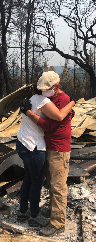 Amy and Chamba with the remains of their home.